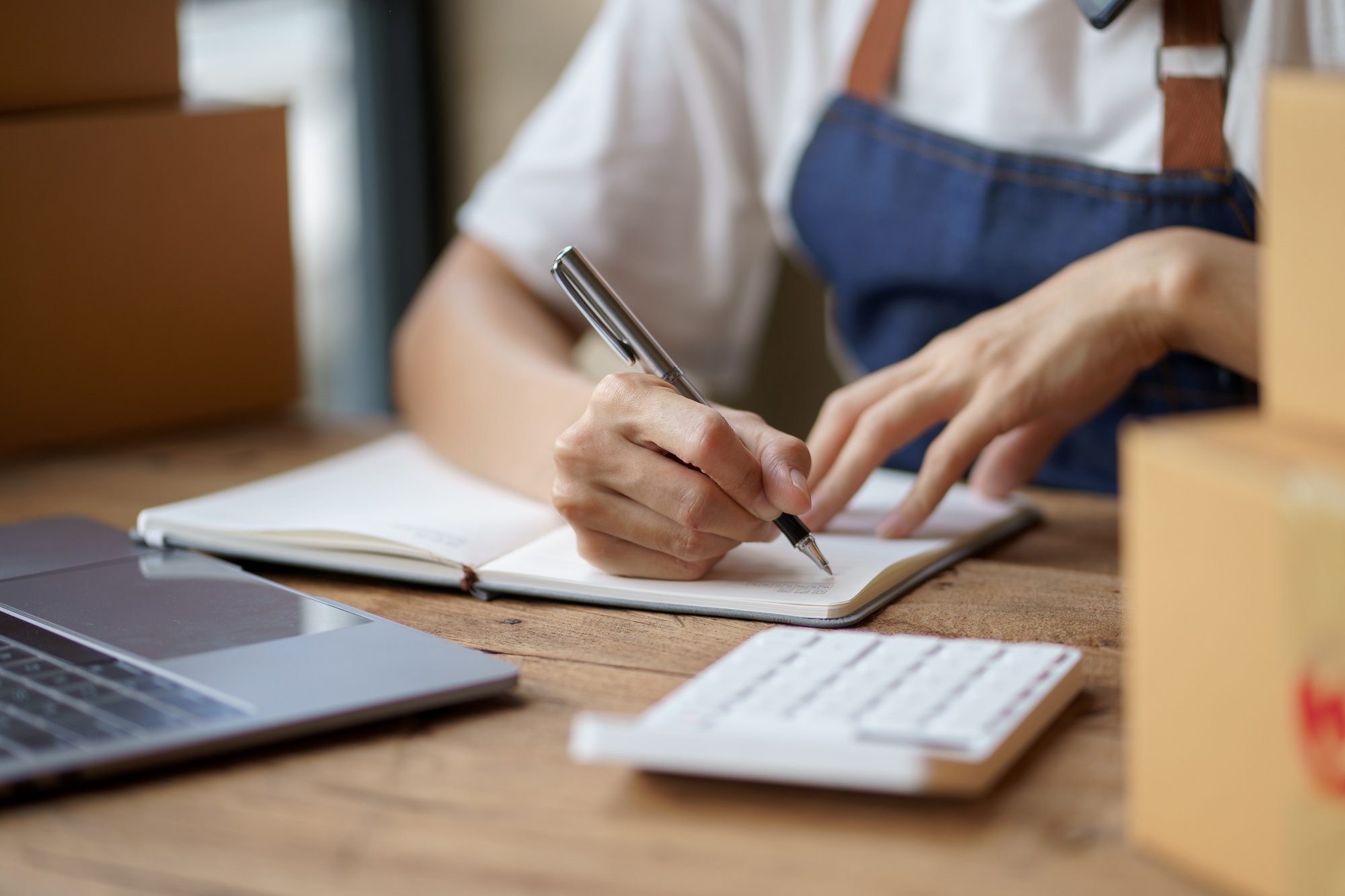 Close-up of an online business owner woman check customer lists to properly pack and ship to custome